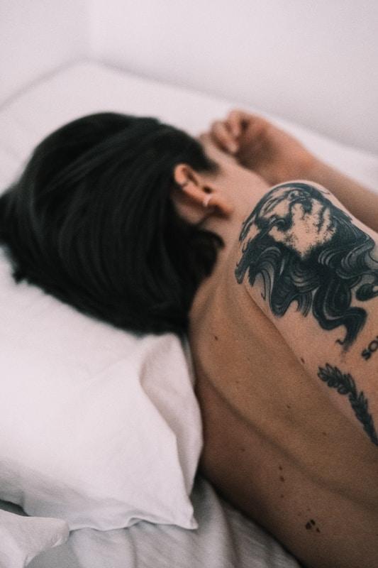 man with black and blue floral tattoo on his back