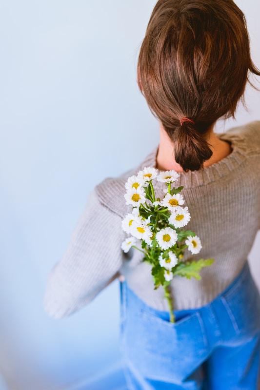 white daisy flowers on woman's pants pocket